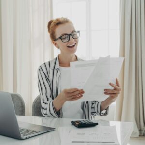 Cheerful professional accountant prepares annual financial report looks at documents