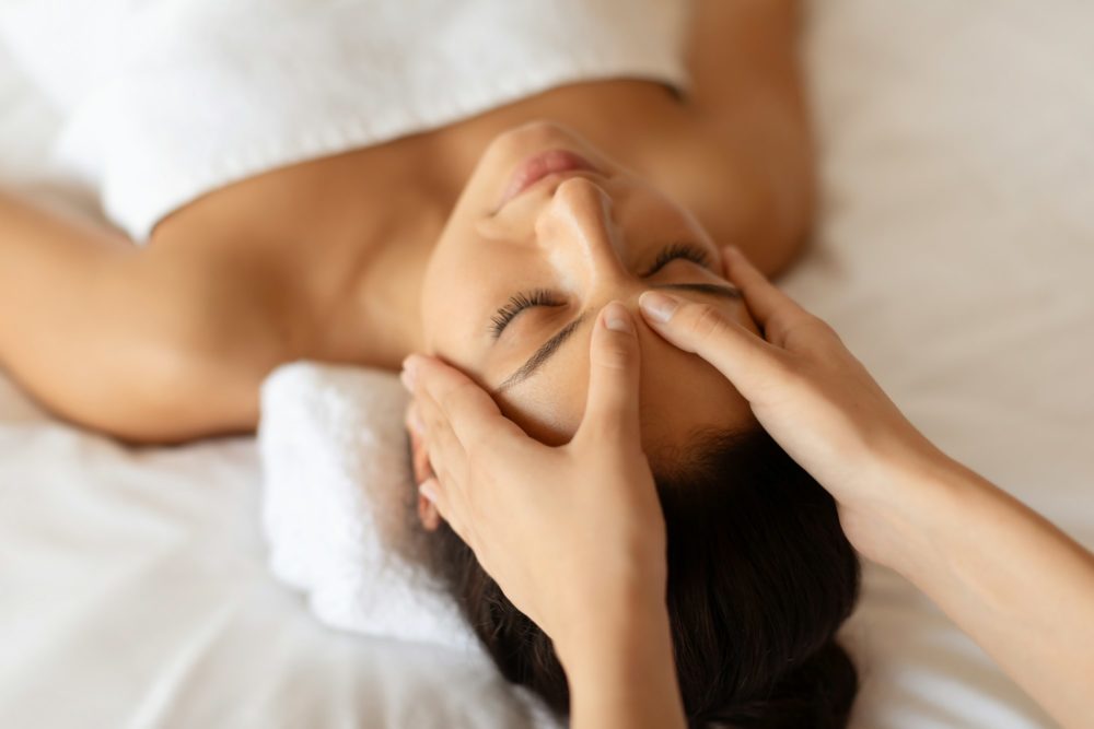 Lady relaxing during acupressure head massage session in spa salon
