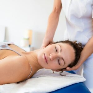 Relaxed woman getting neck treatment in osteopathy clinic